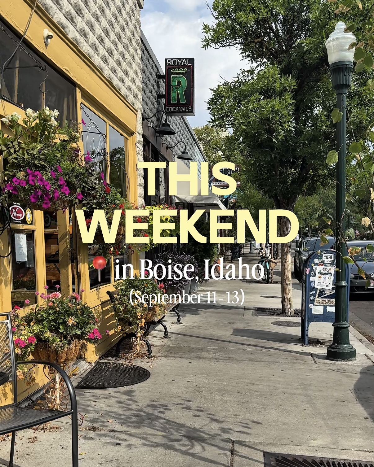 Hanging flower baskets decorate a storefront along a tree-lined Boise sidewalk in Hyde Park with text for weekend events.